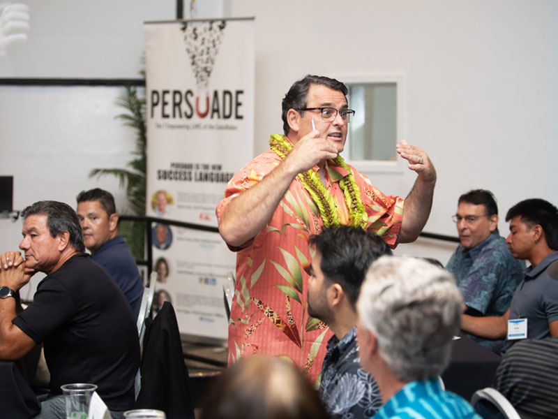 SME Honolulu networking event speaker presenting in Waikiki Honolulu Hawaii, man wearing aloha shirt and lei engaging business professionals in leadership discussion and community networking