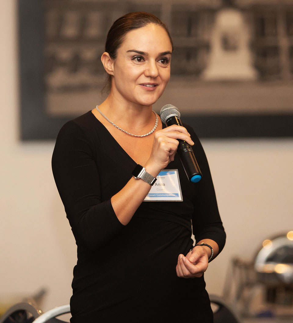 Anna Covert of Covert Communication speaks at an SME Honolulu event, holding a microphone during her presentation.