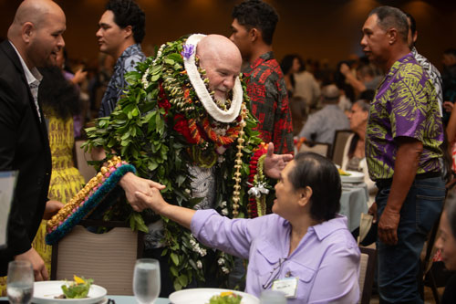 SME Honolulu SPOY banquet event honoree wearing lei greeting guest in Waikiki Honolulu Hawaii, featuring leadership recognition, business networking, and community engagement with local business leaders