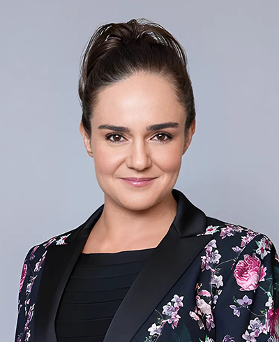 Anna Covert, SME Honolulu Board of Directors member, in a professional portrait with a teal background.