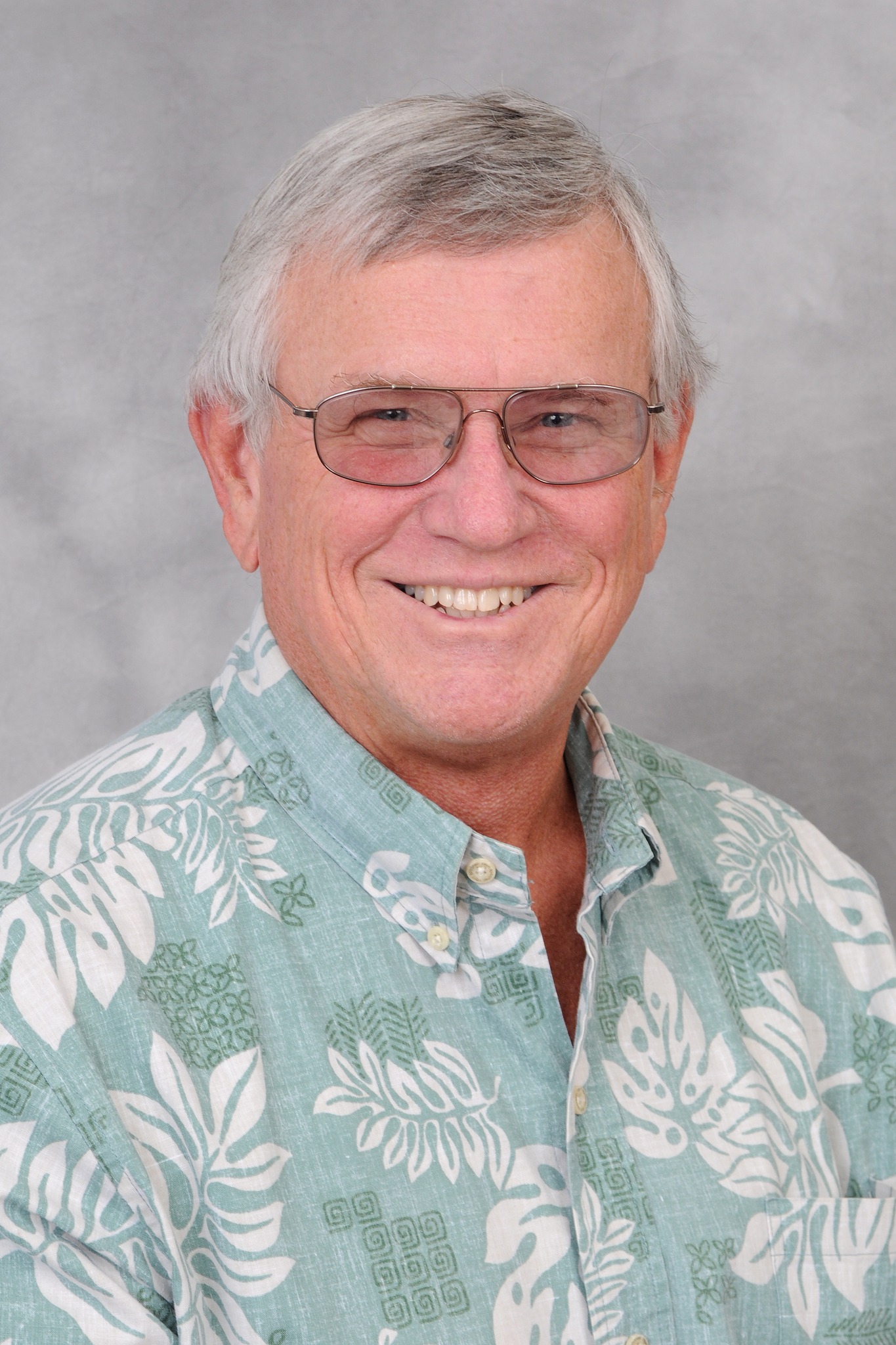 Chad Buck, SME Honolulu member, smiling with arms crossed in a warehouse setting wearing an aloha shirt.